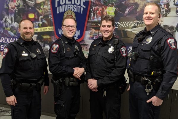 Police Officers in front of department mural