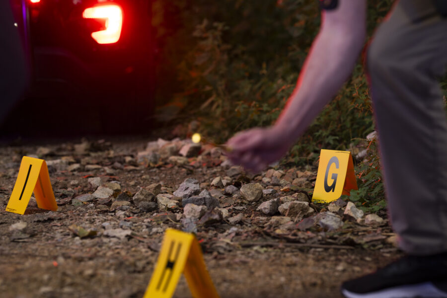Evident tents with letters on them on the ground with headlights glowing in the background